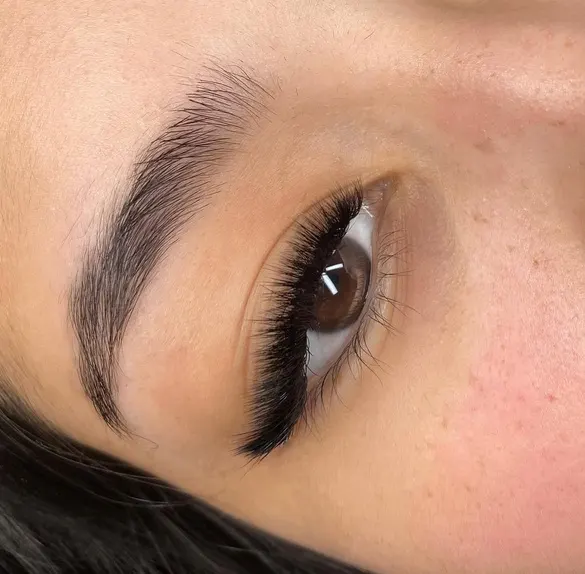 Ojo con extensiones de pestañas efecto foxy, más largas hacia el extremo externo, y ceja perfilada