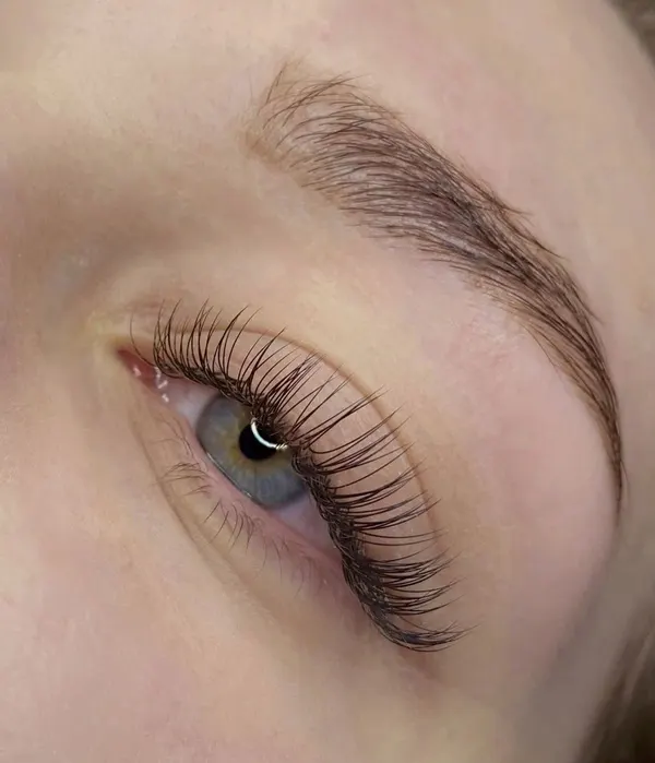 Primer plano de un ojo claro con extensiones de pestañas efecto natural, largas y definidas